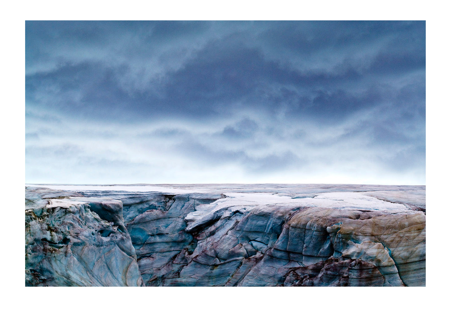 A storm front rises over a rugged and weathered glacial cap stained by blue and pink Snow Algae, Cryoalgae...This region of the Antarctic Peninsula has undergone one of the highest .temperature increases in the world over the past 50 years. The mean annual temperature has risen by >3°C and has been responsible for a significant thinning of ice caps, recession of glaciers and break-up of ice shelves...Galindez Island, Argentine Islands, Faraday Islands, Antarctic Peninsula, Antarctica