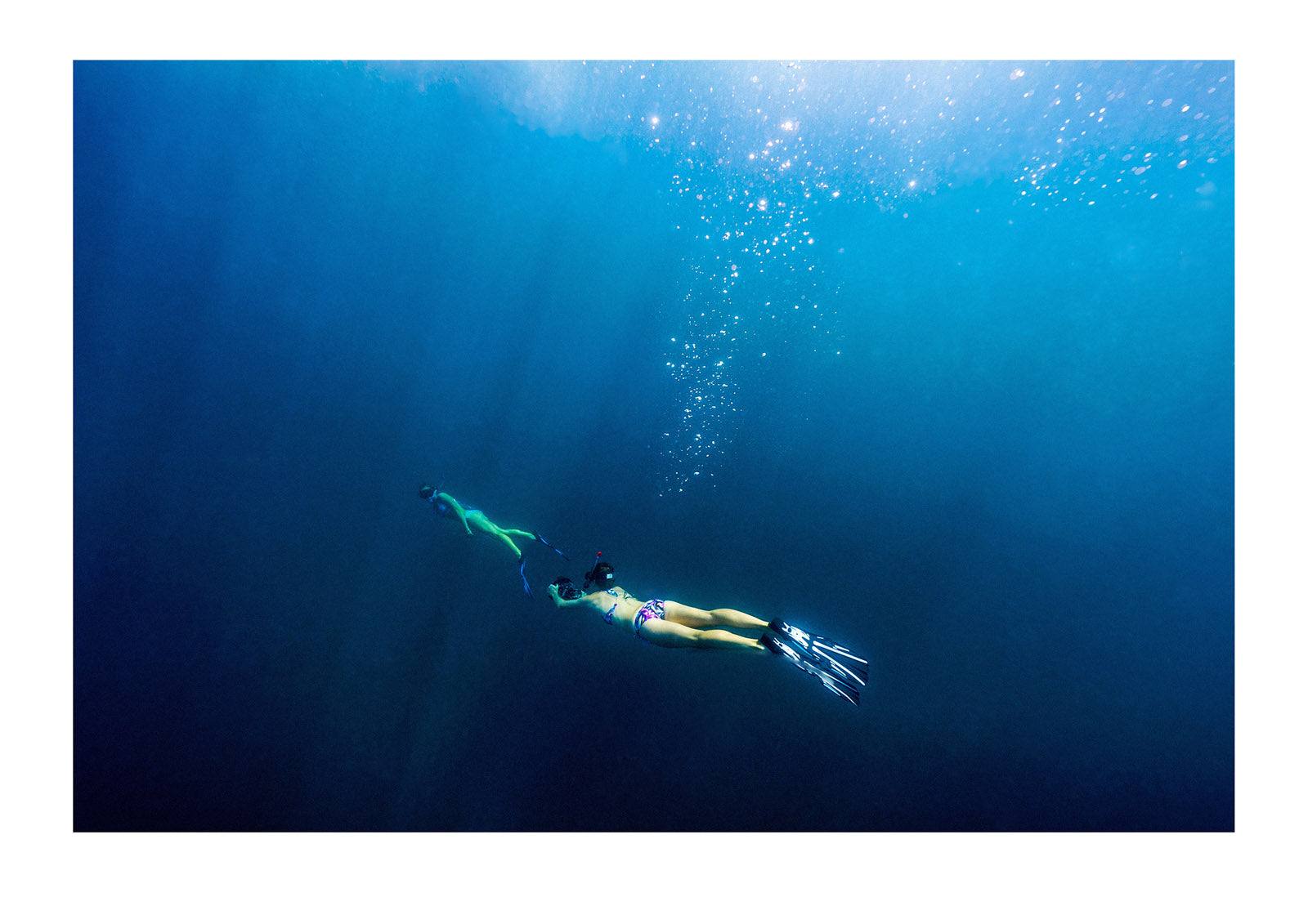 Two free-divers video each other descending into the ocean depths. Exmouth, Ningaloo Reef, Ningaloo Marine Park, Western Australia, Australia.