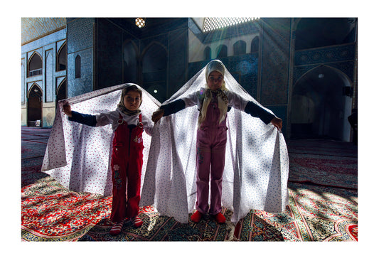 Girls wearing white chador covered in flowers whilst visiting a mosque during Nowruz Iranian New Year. Jame Mosque of Yazd, Yazd, Yazd Province, Islamic Republic of Iran.