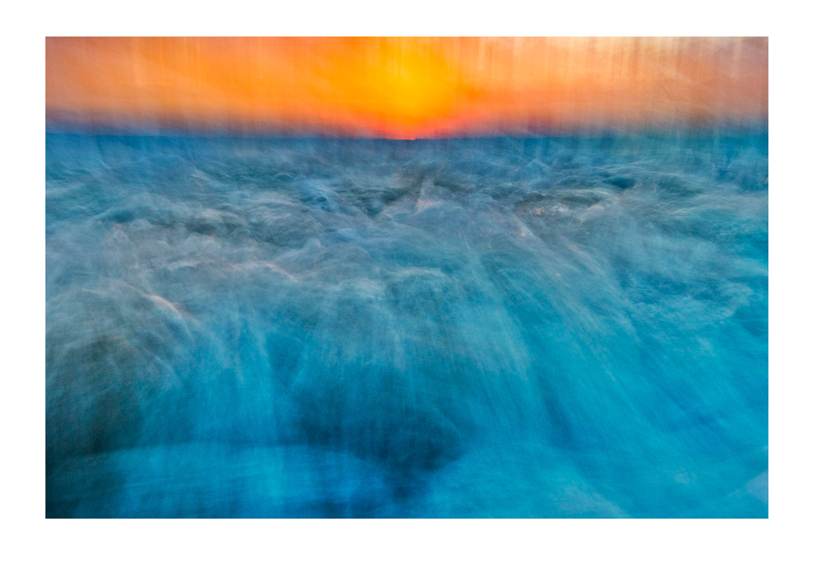 The blur of waves rushing onto a beach on an incoming tide at sunset. Venus Bay, Victoria, Australia. Venus Bay, Victoria, Australia.