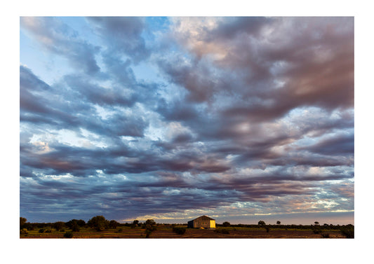 Storm clouds roll in over a shearing shed on an outback sheep station in the desert. Coober Pedy, Mt Willoughby Station, South Australia, Australia