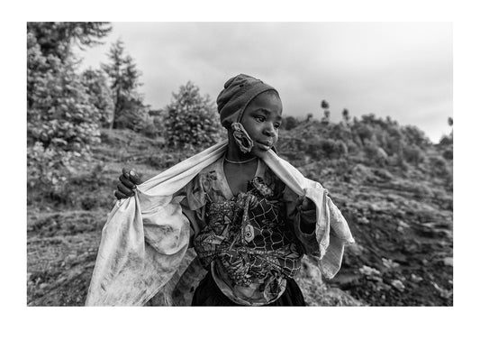 A girl in a village working on a farm near endangered Mountain Gorillas.  Volcanoes National Park, Parc National des Volcans Rwanda.