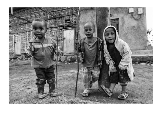 Curious boys in a village greet hikers on their way to see endangered Mountain Gorillas.  Volcanoes National Park, Parc National des Volcans Rwanda.