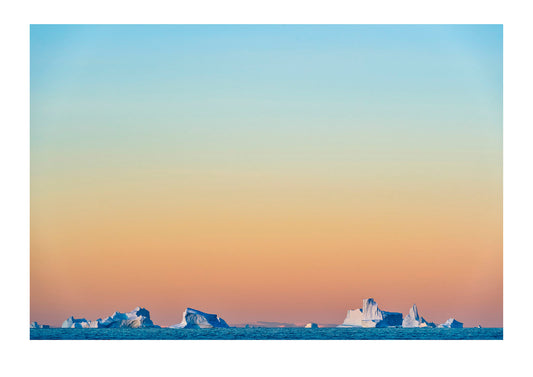 Pastel pink and purple lights Crevasse jagged icebergs rising from the arctic sea at sunset. Milne Land, Hall Bredning Fjord, Scoresby Sound, Greenland