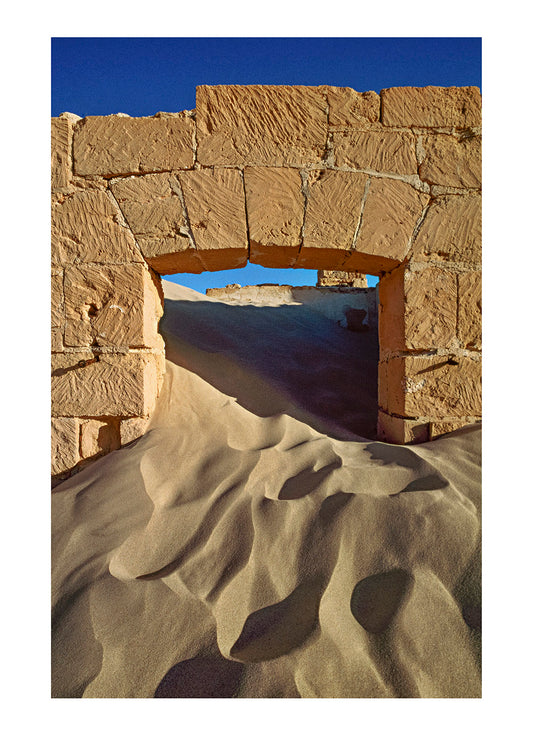 Sand pours through an old telegraph station doorway. Eucla, Western Australia.